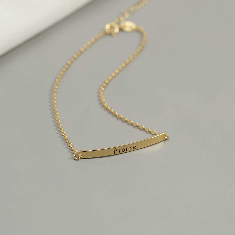Curved gold name bar with stainless steel chain, custom message bracelet close-up