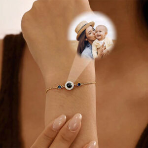 Personalized birthstone photo projection bracelet worn on wrist, light shining through bead revealing photo
