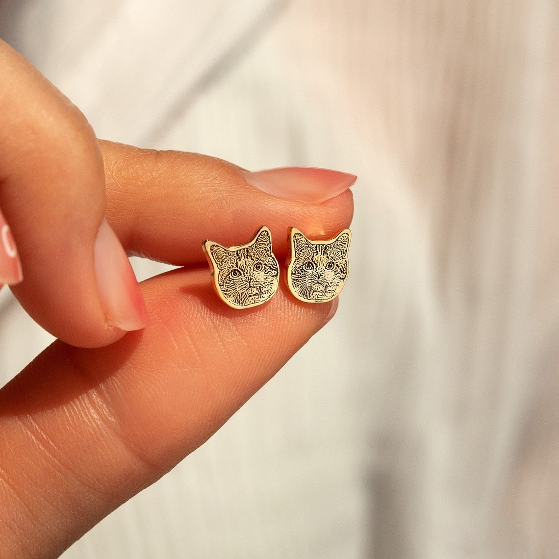 Holding custom dog cat face stud earrings, personalized pet portrait jewelry