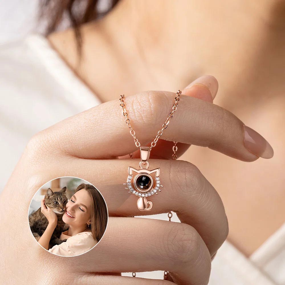 Rose gold cat picture projection necklace held in hand, showing projected woman hugging her cat photo