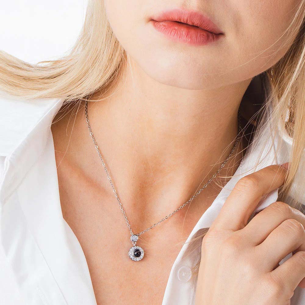 Blonde woman wearing silver halo circle projection necklace, minimalist everyday look in white shirt
