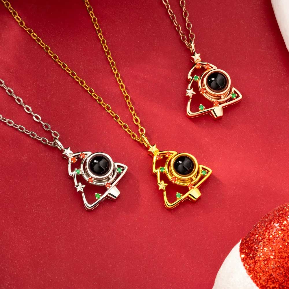 Christmas tree photo projection necklaces in gold, silver and rose gold on red holiday background
