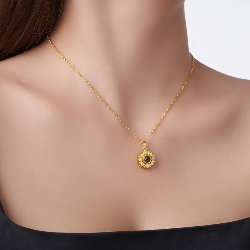 Woman wearing gold sunflower projection necklace, floral heart petal pendant close up