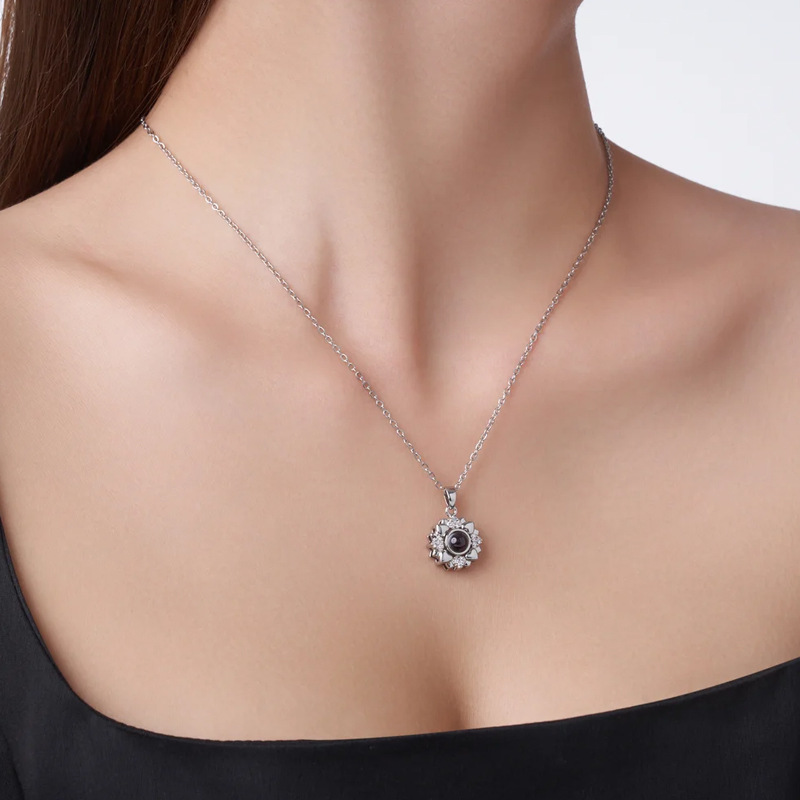 Woman wearing silver sunflower heart petals necklace, delicate flower pendant on neckline